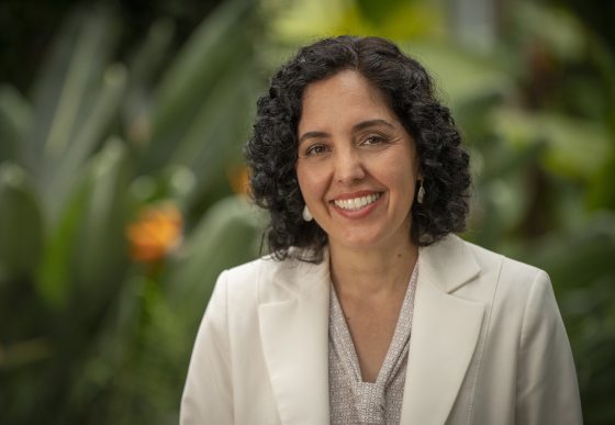 person in a white suit smiling at the camera